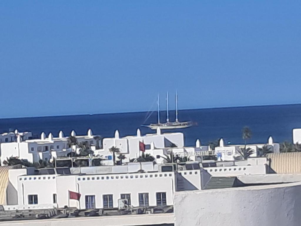 a white building with a boat in the water at mdiq in M'diq