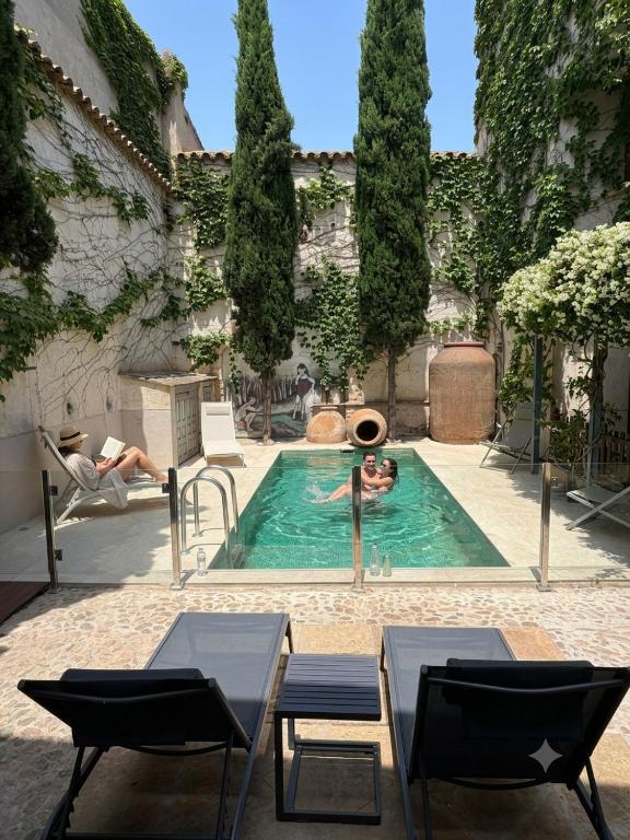 a person swimming in a pool in a courtyard at Hotel Rural La Vida de Antes in Consuegra