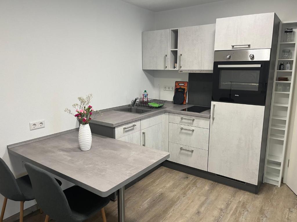 a kitchen with a table with a vase of flowers on it at Ferienwohnung Krayenbergblick 1 in Bad Salzungen