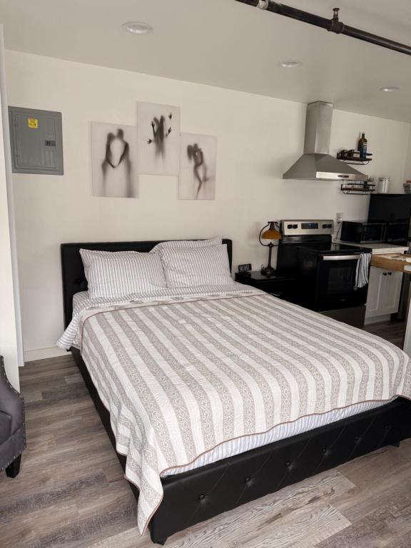 a bedroom with a bed with a striped comforter at Soundview Ferry Cottage in Mukilteo