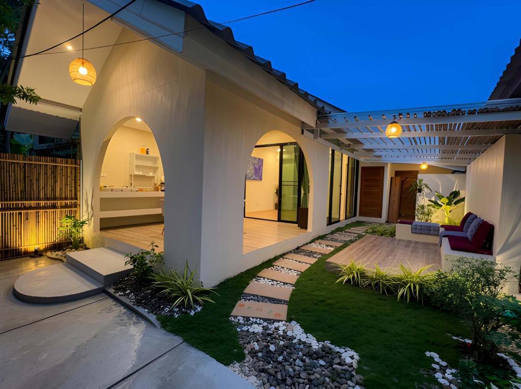 a home with a patio and yard at night at The Arya Srithanu in Ko Kong Nui