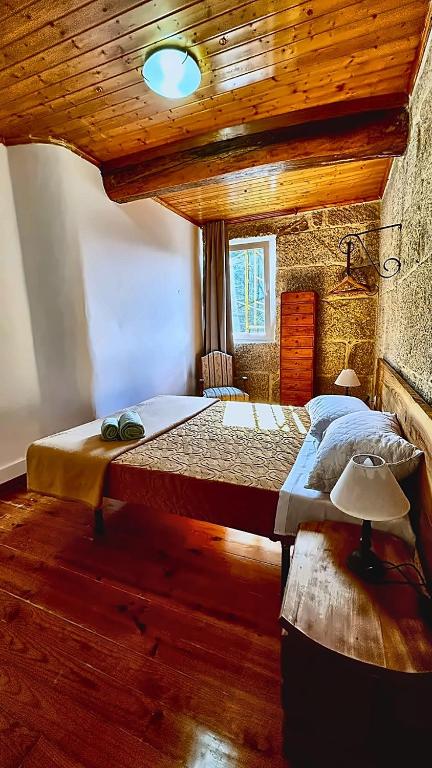 a bedroom with a large bed with a wooden ceiling at Border Bridge House in Tui