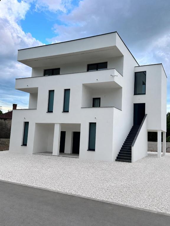 a white house with a staircase in front of it at Villa Koćuša in Ljubuški