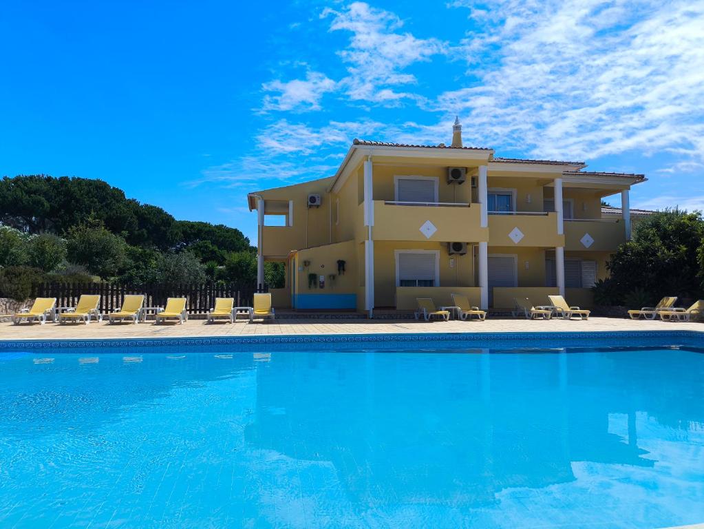 a villa with a swimming pool in front of a house at Aurora Sol in Luz