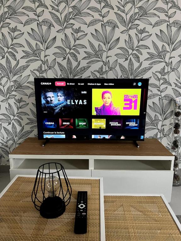 a flat screen tv sitting on top of a table at Maison 2 couchages - parking in La Chaussée-sur-Marne