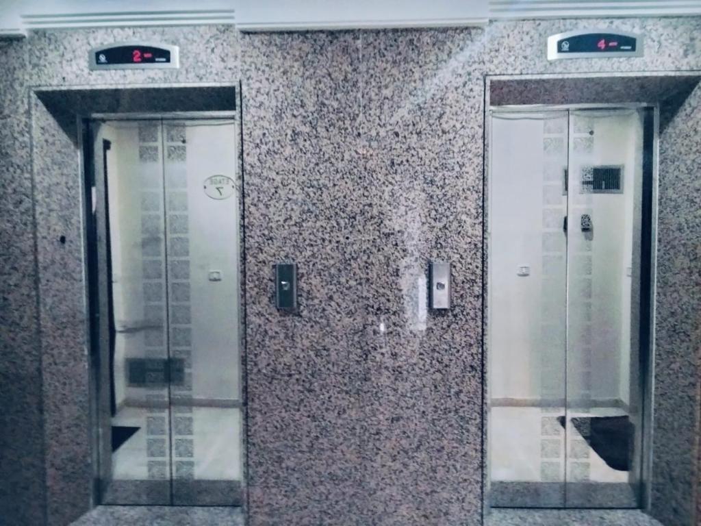 two elevators on a wall in a building at belle appart de luxe CUN in Tunis