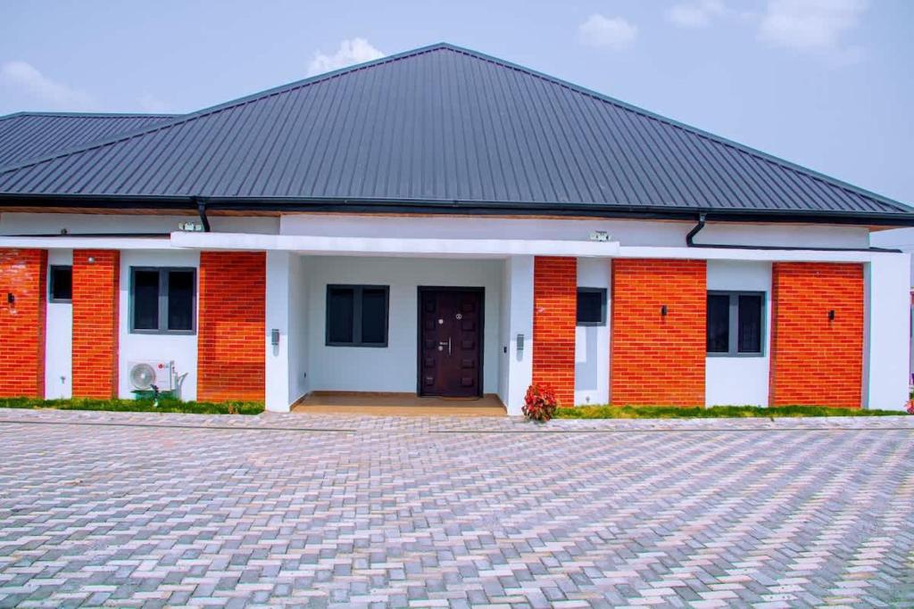 ein rotes Backsteingebäude mit schwarzem Dach in der Unterkunft Zenith House in Ibadan