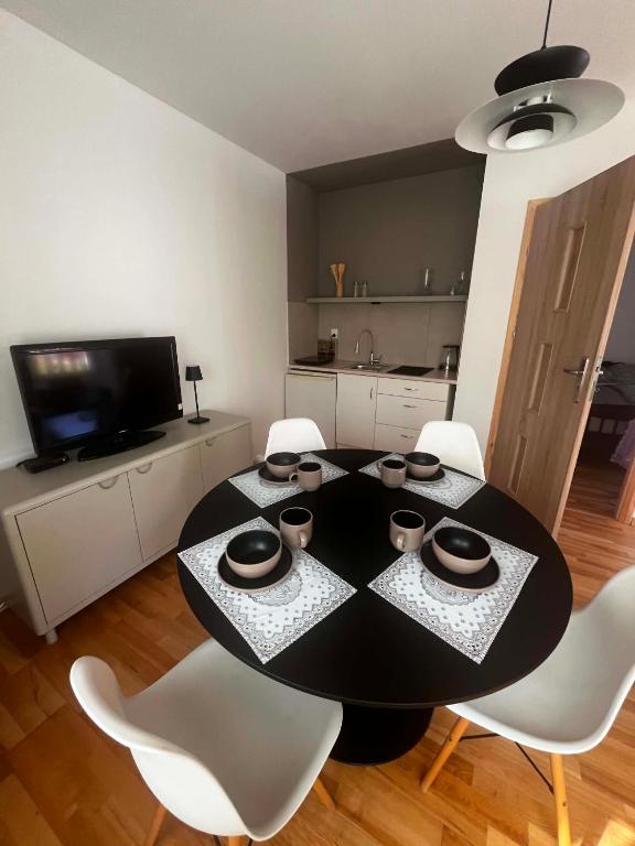a dining room with a table and white chairs at Domek Augustów Monika in Augustów