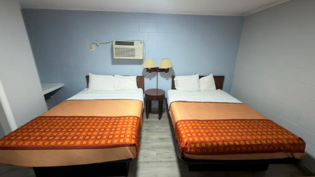 a room with two beds in a room with a heater at Ada Inn & Suites in Ada