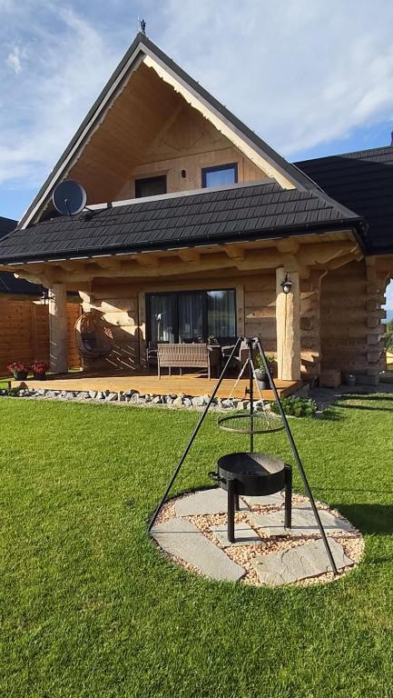 a swing in a yard in front of a house at Sękata Chata góralski domek z kominkiem in Szaflary