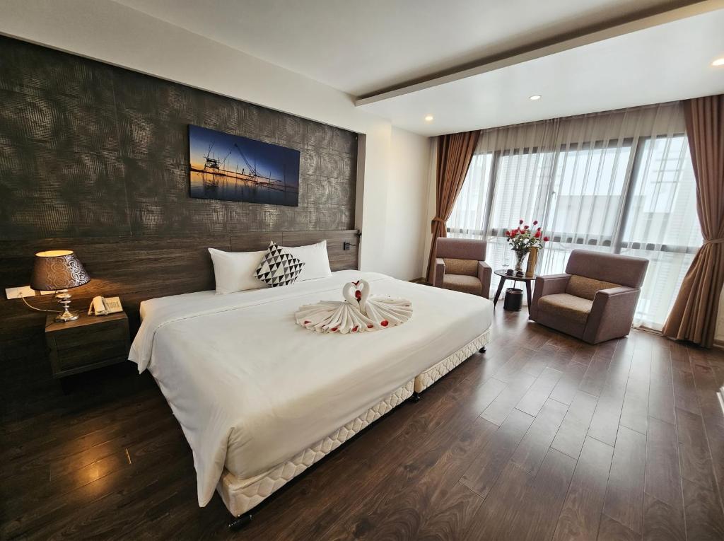 a bedroom with a large white bed and a chair at Moon Hotel 66 Bui Thi Xuan in Hanoi