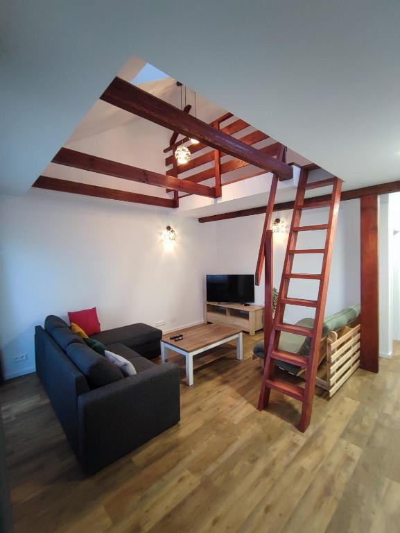 a living room with a ladder and a couch at Apartmán Štiavnik in Vysoké Tatry