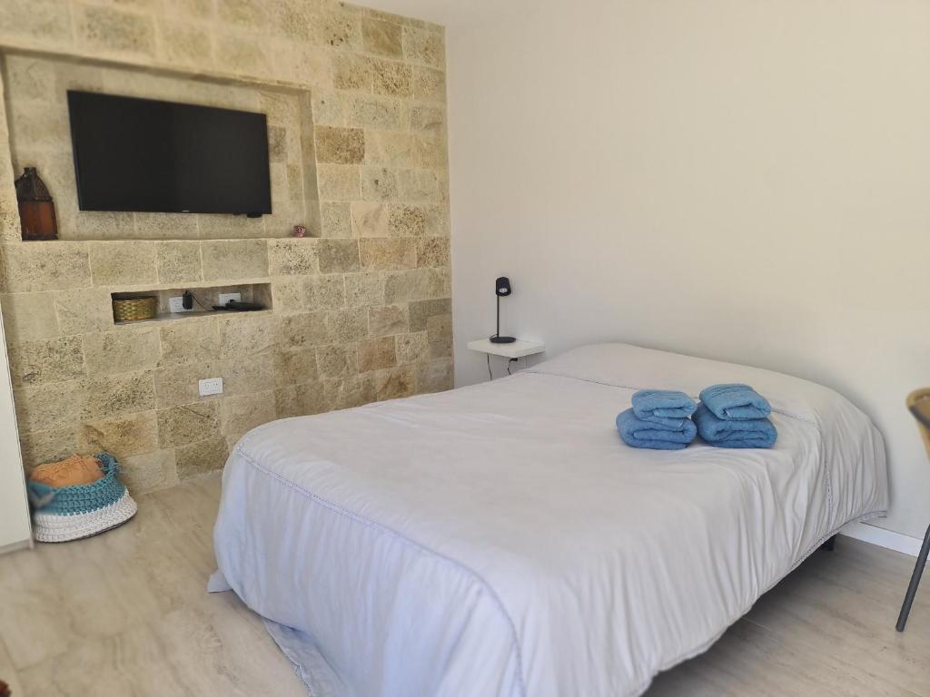a bedroom with a bed with two blue towels on it at Los Medanos 1 in Puerto Madryn