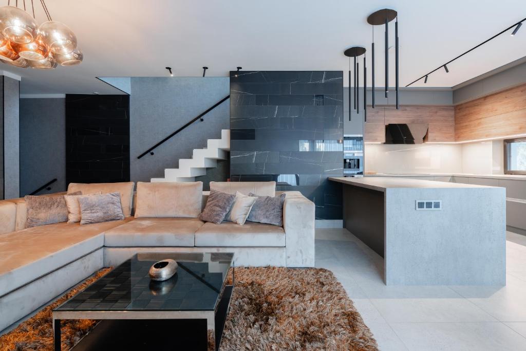 a living room with a couch and a table at Villa Glam Wellness & Spa Retreat in Mogyoród