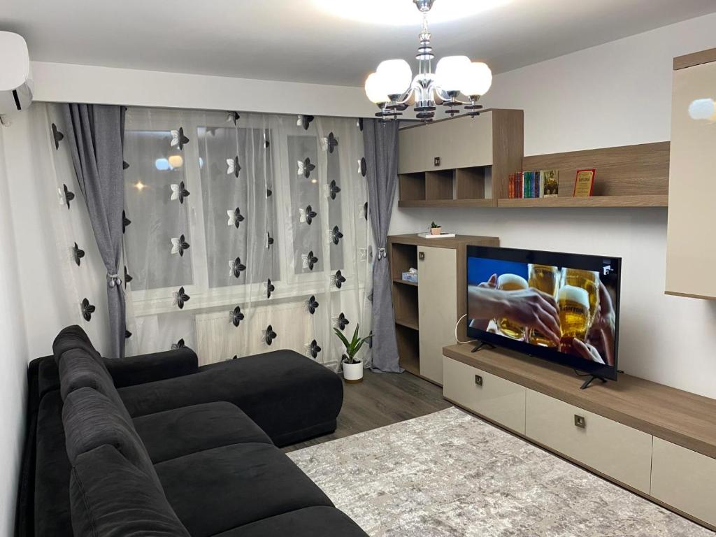 a living room with a couch and a flat screen tv at Alina Home in Mediaş