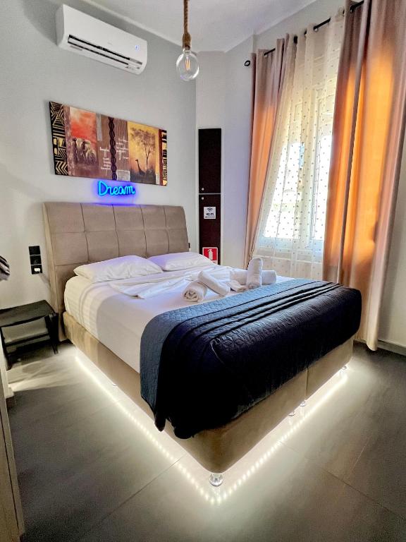 a bedroom with a large bed with a lighted bedvisor at Phoenix Garden Apartments -1- in Athens