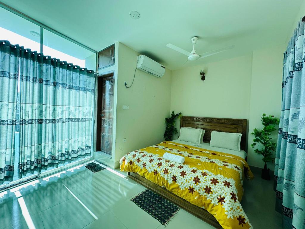 a bedroom with a bed and a large window at Hotel Nice Look Kuakata in Kuākāta
