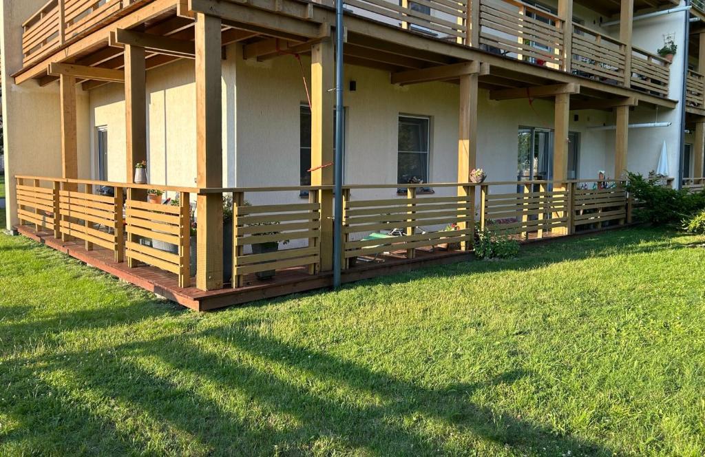 a house with a porch and a grass yard at Butas Karklėje in Karklė