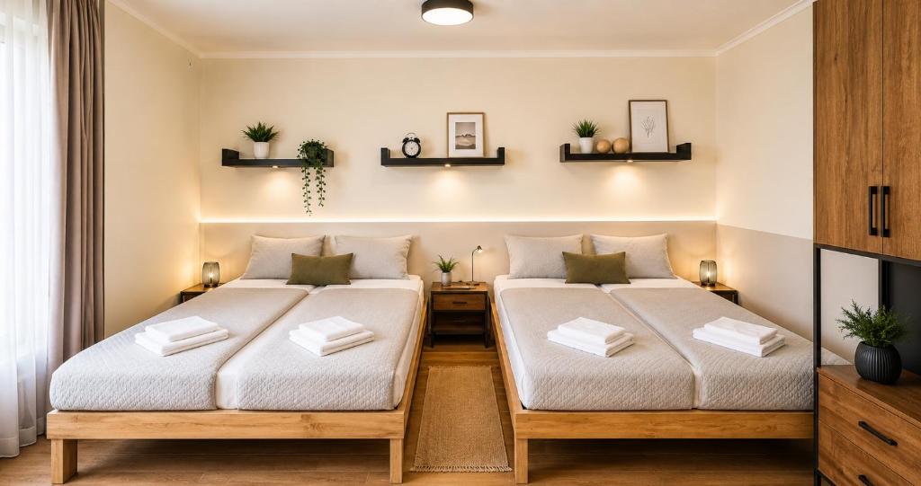 two beds in a small room with white sheets at Park and Fly Belgrade Airport Apartments in Surčin
