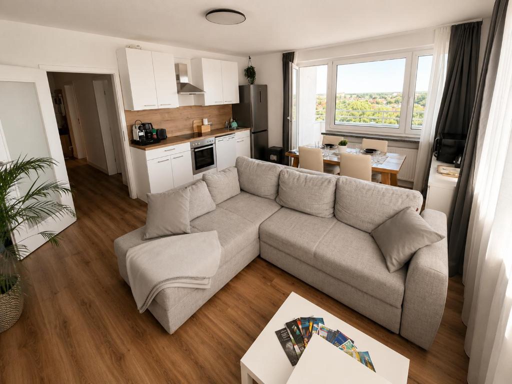 a living room with a couch and a kitchen at Apartment Hannover - Langenhagen center in Hannover