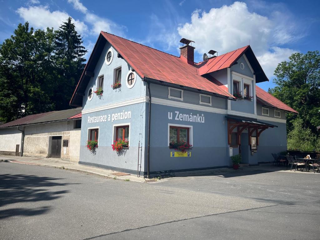 a blue and white building with a red roof at Penzion U Zemánků in Jablonec nad Jizerou