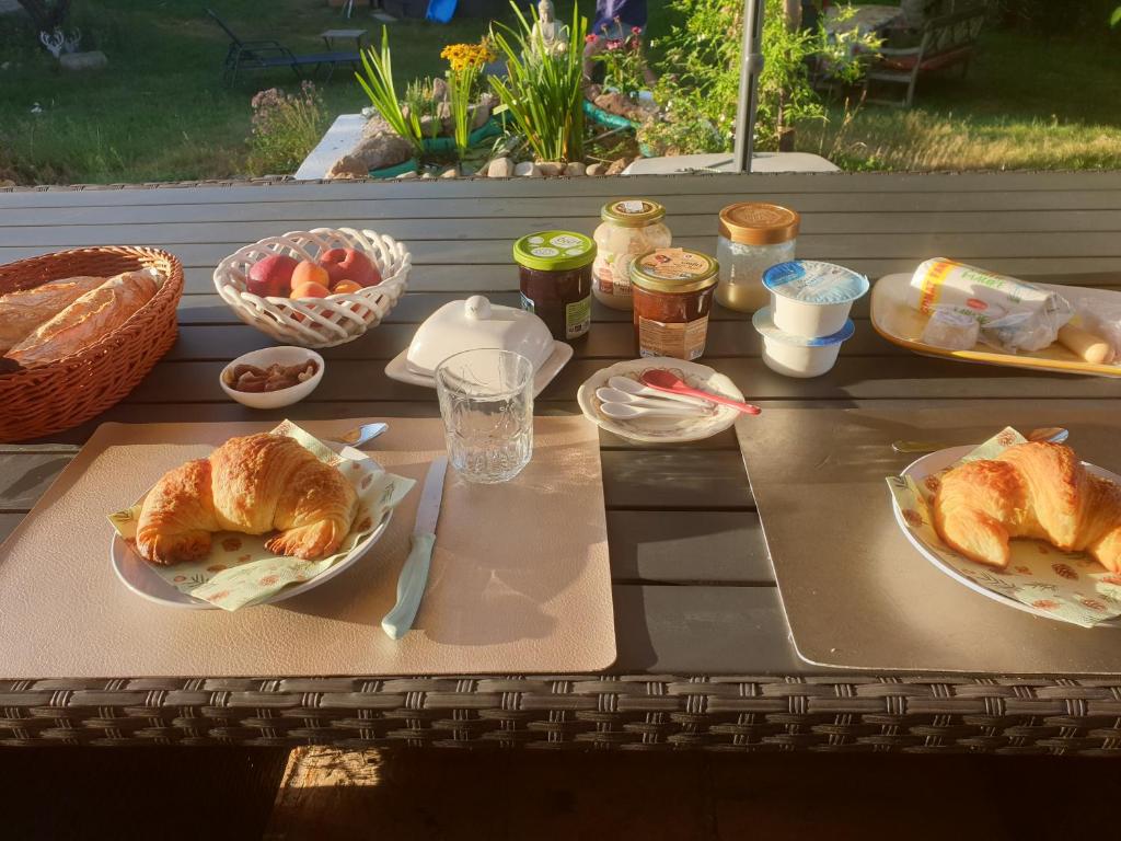 a picnic table with plates of food on it at Nature & bien-être - 1 chambre à l'étage in Étival-Clairefontaine