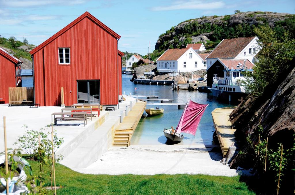 une grange rouge et un bateau dans un port dans l'établissement Verftet i Ny-Hellesund, à Søgne