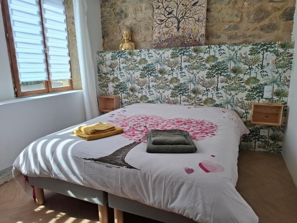 a bedroom with a bed with pink flowers on it at La Vie Est Belle in Salles-la-Source