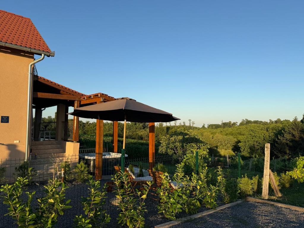 a patio with an umbrella next to a building at Deer Hill in Orahovica