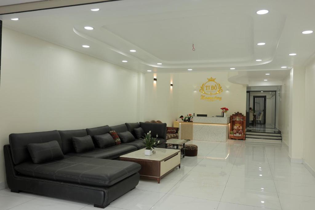 a living room with a black couch and a table at Ti Do Homestay in Ðức Hòa