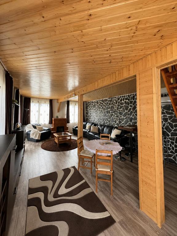 a living room with wooden ceilings and a room with a couch at Coco & Simi Lakeside Nest in Cinciş