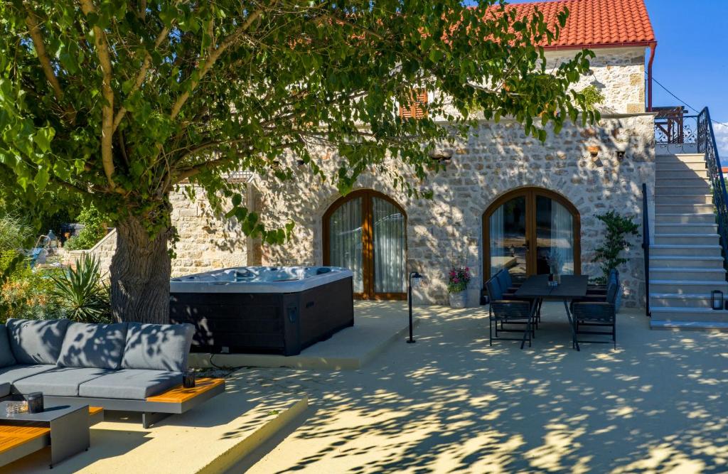 a patio with a hot tub and a tree at Filindvor in Nin