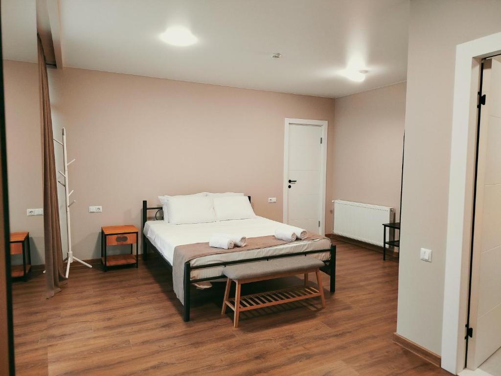 a bedroom with a bed and a wooden floor at Hotel Aura in Zugdidi