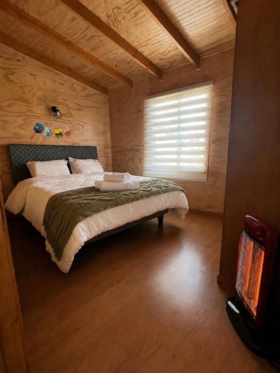 a bedroom with a large bed with a window at Departamento Nu_Be2 Castro Chiloé in Castro
