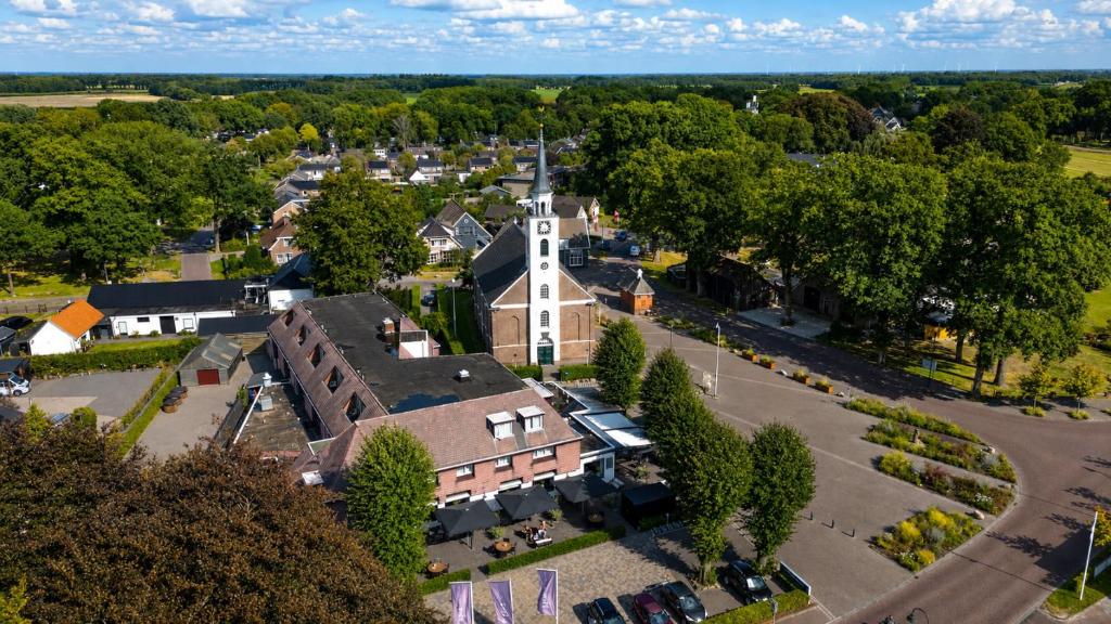 Luftaufnahme einer Kleinstadt mit einer Kirche in der Unterkunft Hotel De Oringer Marke Odoorn, nabij Emmen in Odoorn