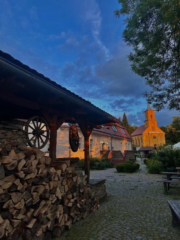 a building with a roof and a pile of wood at Karczma Bełty in Glinno