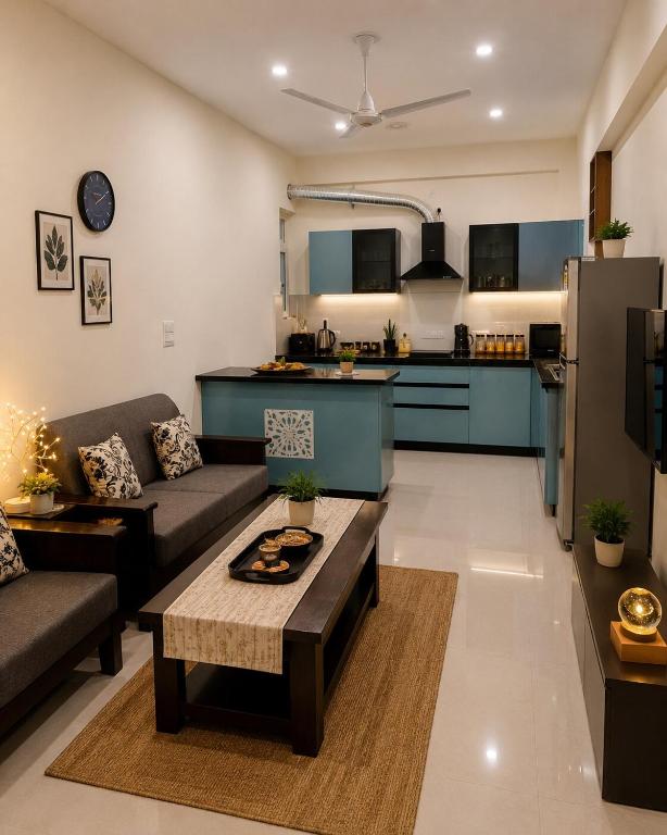 a living room with a couch and a kitchen at The Azure Loft Nestory Stays in Rājpur
