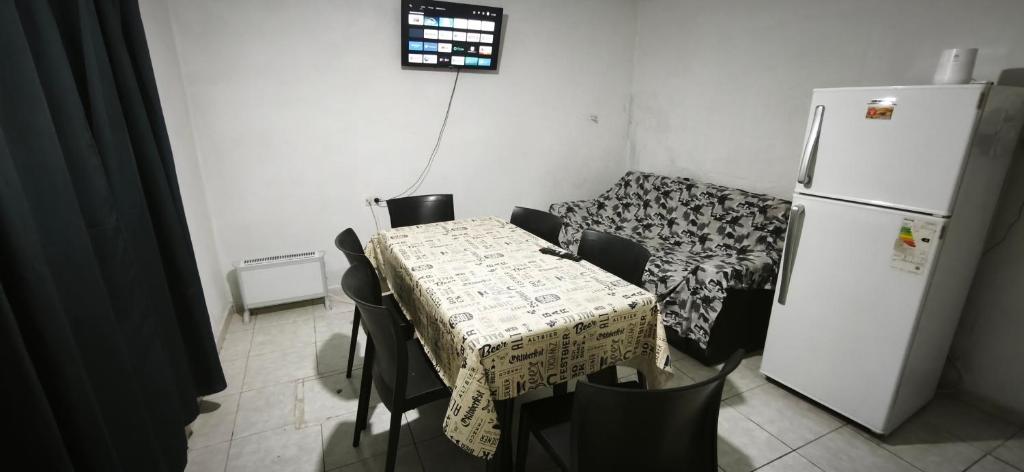 a small kitchen with a table and a refrigerator at El ROBLE 2 in Córdoba