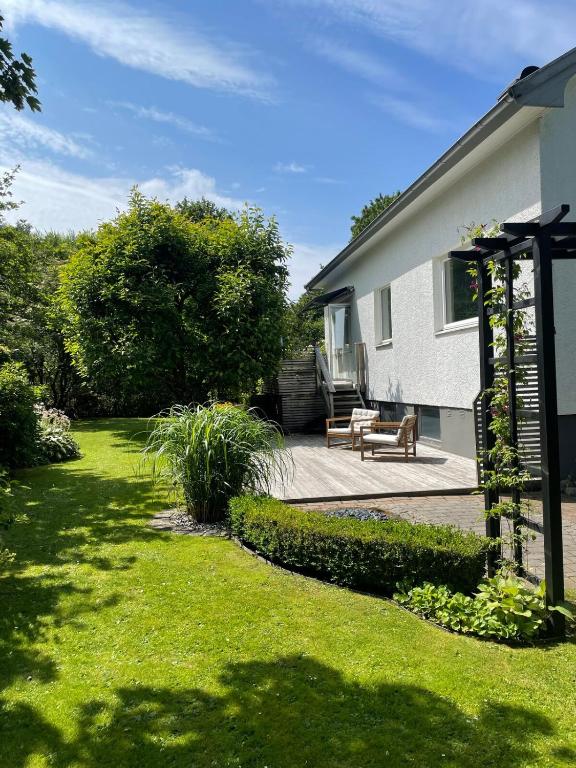 a yard with a house and a bench and grass at Villa in Gothenburg in Gothenburg