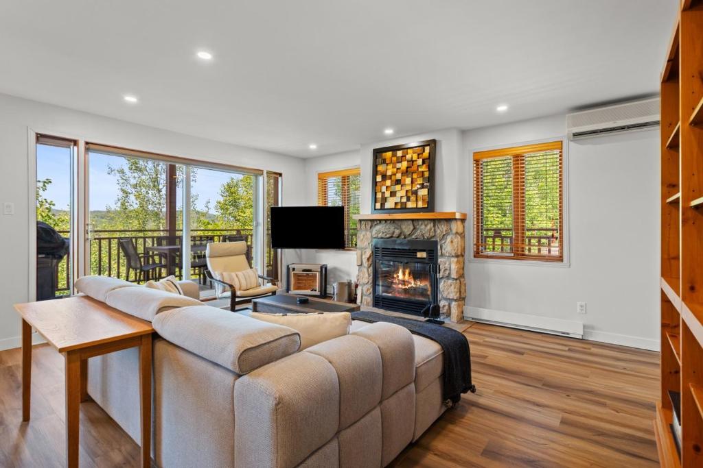 a living room with a couch and a fireplace at Hauts-bois Ski Inout 2brs Wpool Access 193-1 in Mont-Tremblant