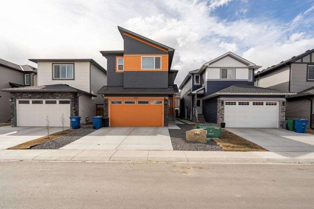 a house with an orange garage in a driveway at Plush Suite Pet Friendly 326 Mbps Wi-Fi in Airdrie