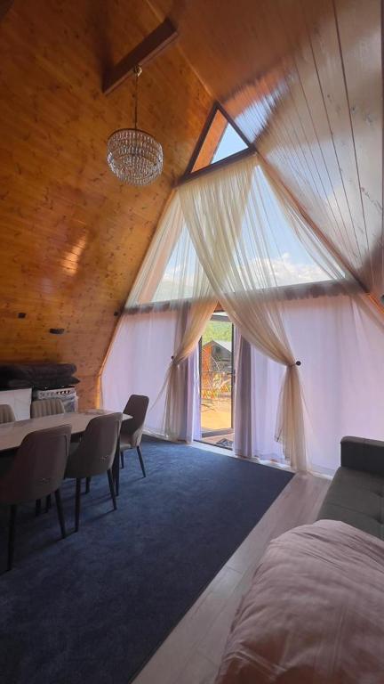 a room with a table and chairs and a large window at Royal Park in Arslanbob