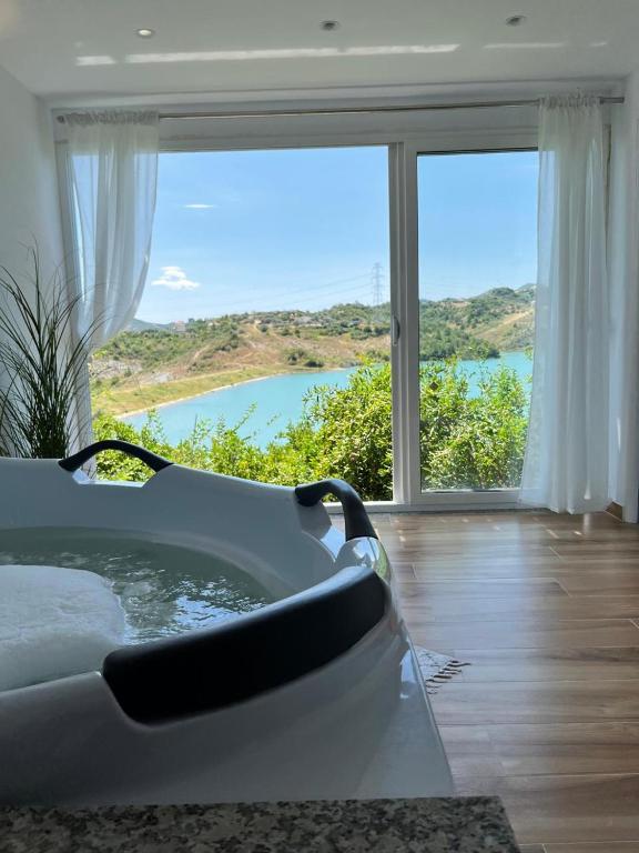 a bath tub in a room with a large window at Lake Breeze in Gjokaj