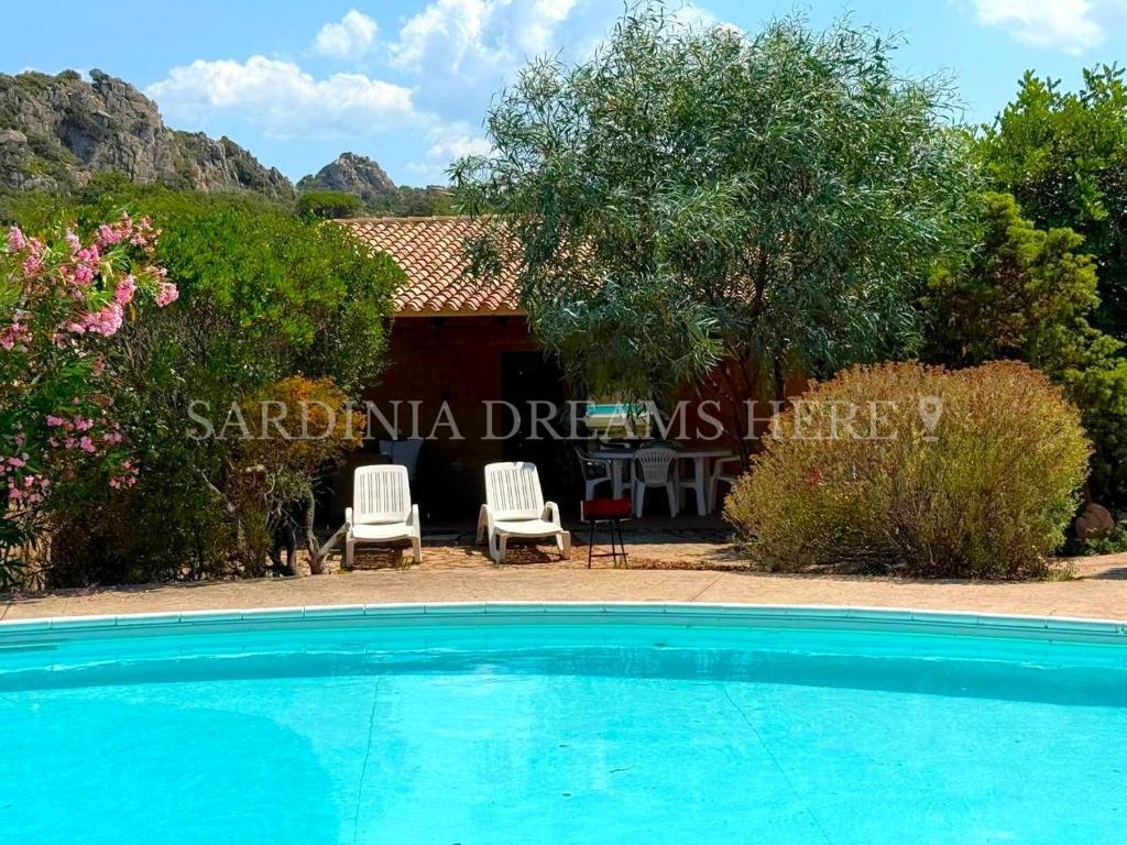 a swimming pool in front of a house at Villa Flavia with pool and private parking in Costa Paradiso