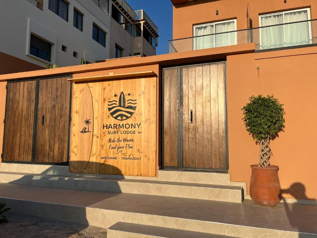 a building with two wooden doors and a tree at Imsouane Harmony in Imsouane