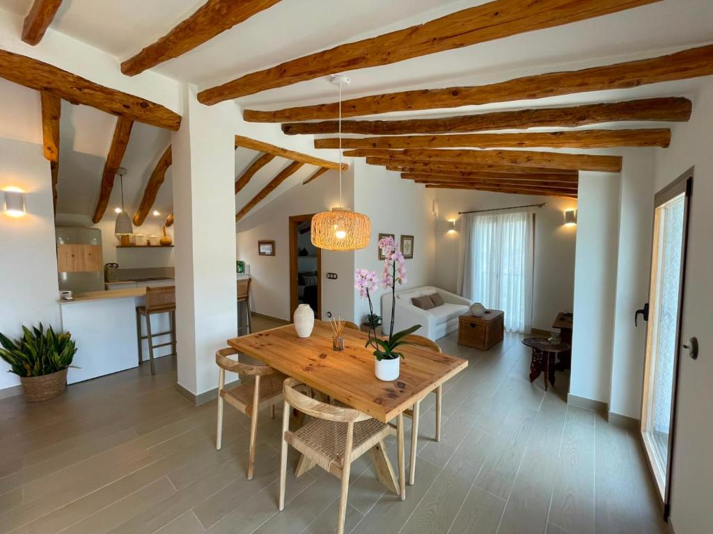 a kitchen and living room with wooden ceilings and a wooden table at El Planet - Apartamento con terraza in Benimantell