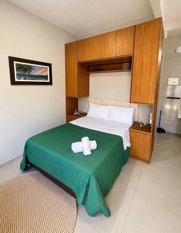 a bedroom with a bed with two towels on it at Maria Lofts in Itaguaí