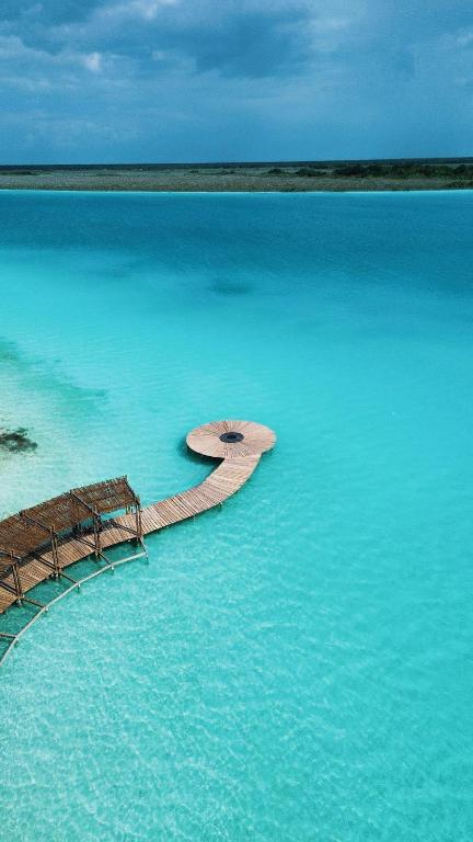 a wooden walkway in the middle of the water at PenthouseLuxury - Laguna PoolPriv Paddles in Bacalar