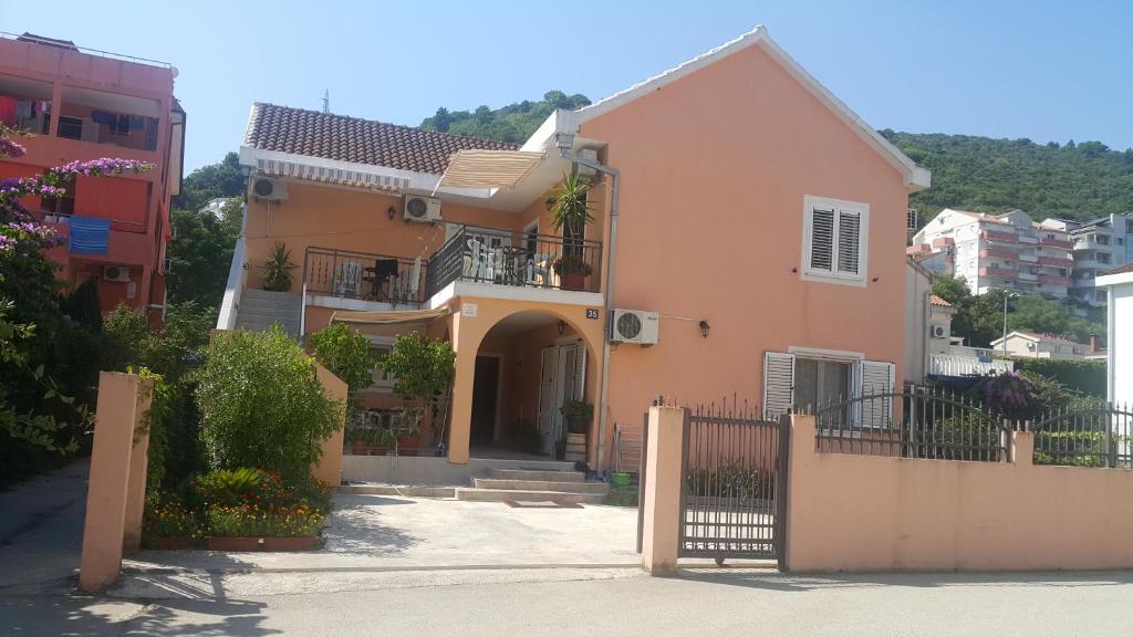 uma casa cor-de-rosa com um portão numa cidade em Sobe Nedović em Budva