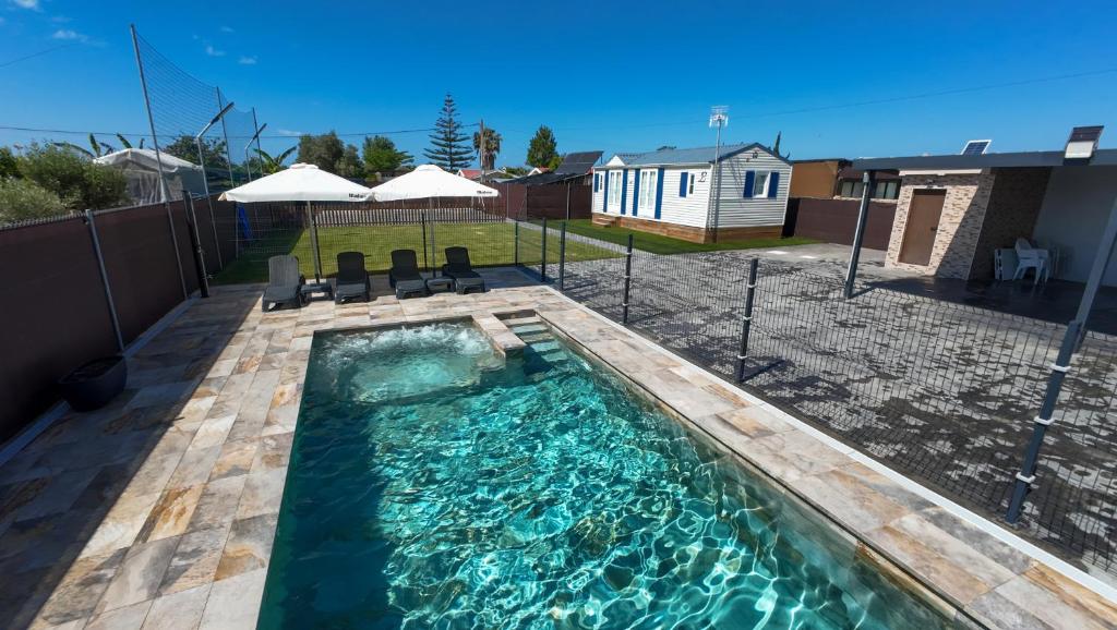 a swimming pool with chairs in a backyard at Villa Thiago in Cádiz